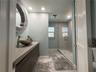 Guest bathroom featuring a walk-in shower and updated finishes.