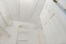 Walk-in closet in the primary bedroom w shelving & access to attic & hot water heater