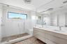 Bathroom featuring a sink, a shower stall, and visible vents