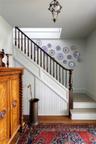 Stairway with wood finished floors and a skylight