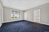 The freshly painted main-level primary suite offers generous space, large windows, and direct access to the ensuite bathroom. New carpeting would easi