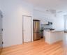 Kitchen featuring stainless steel appliances, white cabinets, light wood-style floors, a kitchen island, and decorative backsplash