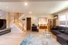 Open-concept living area featuring light wood-finish flooring, recessed ceiling lighting, a built-in linear fireplace with a marble-finish surround, a