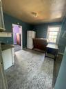 Kitchen featuring refrigerator, a baseboard heating unit, and light floors