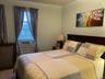 Carpeted bedroom with radiator heating unit and cooling unit