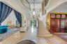 Entrance foyer with a high ceiling, stairway, ornamental molding, recessed lighting, and arched walkways
