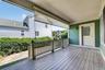 The covered porch doubles as a breezeway, creating a sheltered outdoor connection between the home and garage.