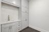 Upstairs laundry room with custom cabinets & utility sink