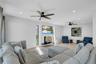 Living area with light wood-style floors, a wood stove, recessed lighting, and a ceiling fan