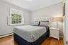 Bedroom with crown molding, a baseboard radiator, and wood finished floors