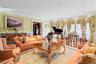 Spacious formal living room with recessed lighting, crown molding, wood-finish flooring, and a large bay window with decorative valances