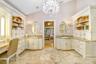 Vaulted ceilings in master bathroom with chandelier and his and her sink areas ample cabinetry for storage.