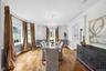 Hardwood flooring, arched doorway, elegant chandelier, crown molding, and wainscoting