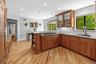 Kitchen with a sink, stainless steel gas stovetop, visible vents, a peninsula, and brown cabinetry
