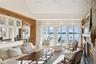 Living room with a water view, a large fireplace, high vaulted ceiling, and recessed lighting