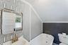 Full bathroom with a soaking tub, wallpapered walls, crown molding, and vaulted ceiling