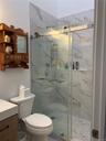 Bathroom with vanity and a marble finish shower
