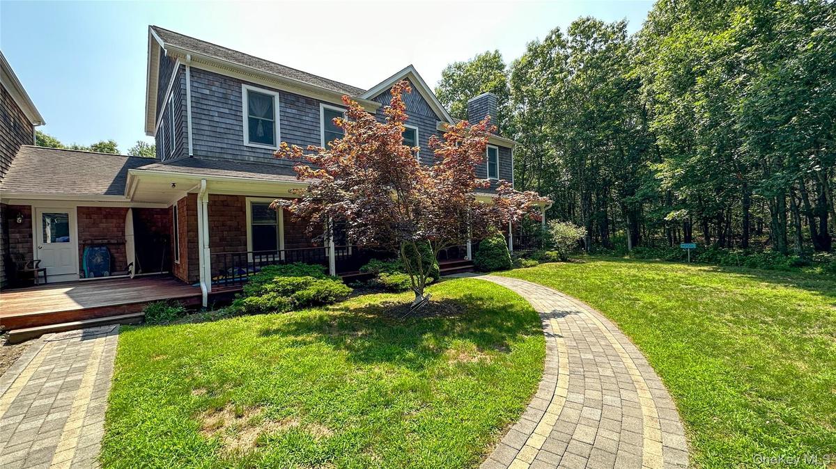 View of front of house featuring a chimney and a front lawn