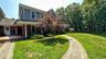 View of front of house featuring a chimney and a front lawn