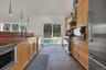 Kitchen with stainless steel appliances, plenty of natural light, a sink, and wall chimney range hood