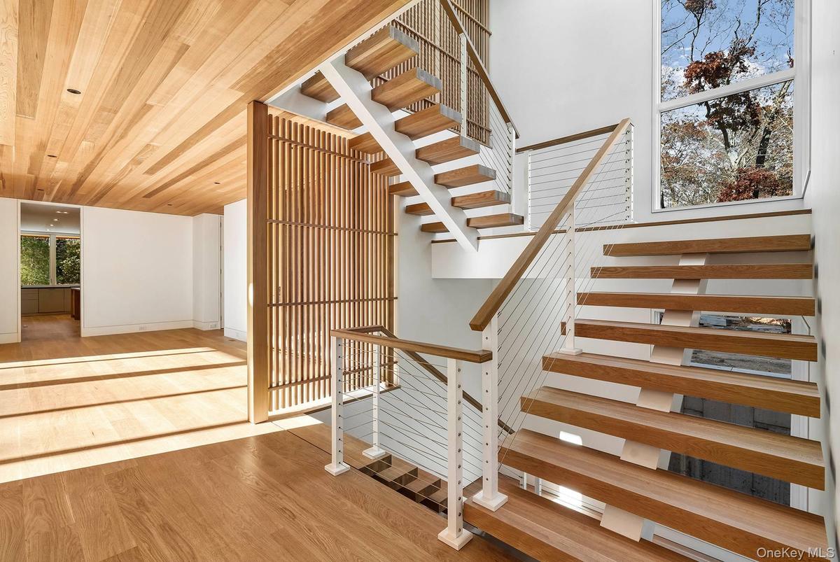 Stairway featuring wood finished floors and wood ceiling
