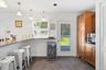 Thoughtfully updated with warm cherry cabinetry, gleaming granite surfaces, stainless steel appliances, a wall oven, and an abundance of pantry storag