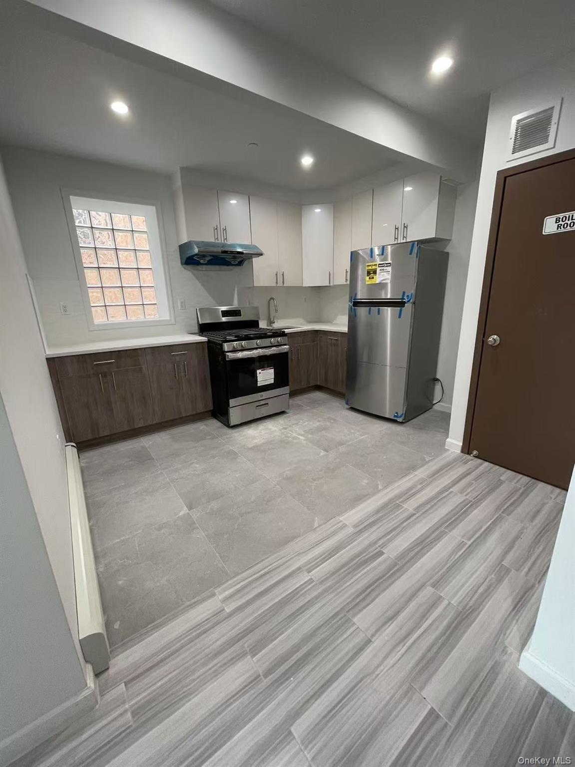 Kitchen featuring stainless steel appliances, light countertops, visible vents, a sink, and under cabinet range hood