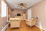 Living room with baseboard heating, light wood-type flooring, ceiling fan, and recessed lighting