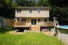 Part of the backyard, new deck with retractable awning, and above-ground swimming pool.