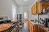Kitchen featuring stainless steel range oven, light countertops, brown cabinets, dark wood-style floors, and exhaust hood