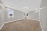 Light-toned wood-finish flooring, recessed lighting, central ceiling fixture, and multiple windows