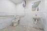 Half bathroom with tile walls, a wainscoted wall, and water heater