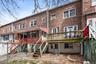 Rear view of property featuring stairs, brick siding, and a deck