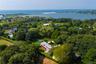 Aerial overview of property's location featuring a large body of water and a heavily wooded area