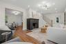Living room featuring wood-finish flooring, a black brick fireplace, recessed lighting, and a modern ceiling light fixture