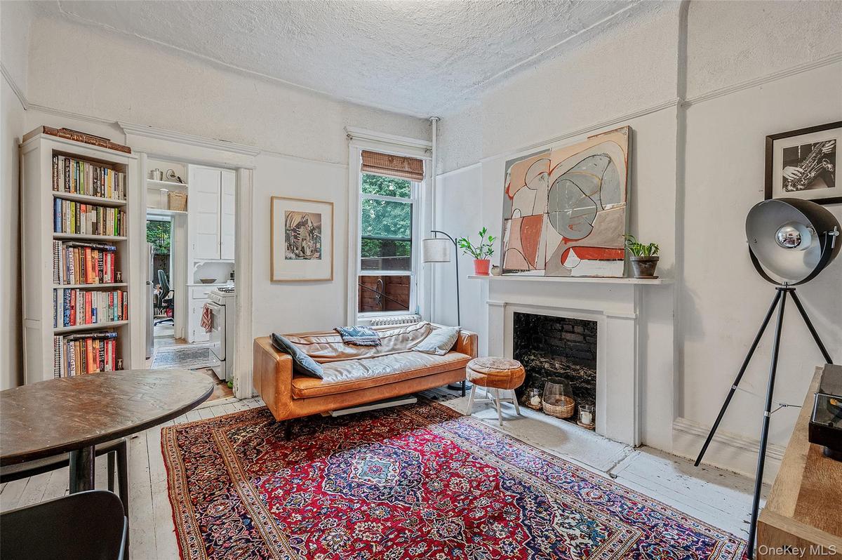 Sitting room featuring a textured ceiling, hardwood / wood-style flooring, and a fireplace with flush hearth