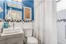 Full bath featuring vanity, tile walls, and shower / tub combo with curtain
