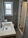 Bathroom with tile walls, vanity, and wainscoting