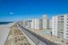 View of apartment building / complex with view of water and beach