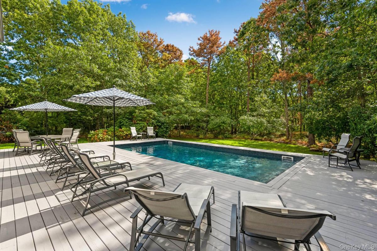 Outdoor pool featuring a wooden deck and a patio