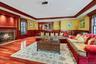 Spacious interior featuring rich wood-finish flooring, a stone-surround fireplace with a wood mantle, and extensive wood paneling and trim