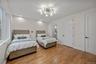 Bedroom with light wood-style flooring, recessed lighting, ensuite bathroom, and a chandelier