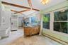 Kitchen with a peninsula, a baseboard heating unit, beamed ceiling, appliances with stainless steel finishes, and tasteful backsplash