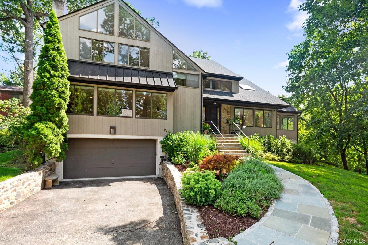 Mid-century inspired home featuring driveway and a garage