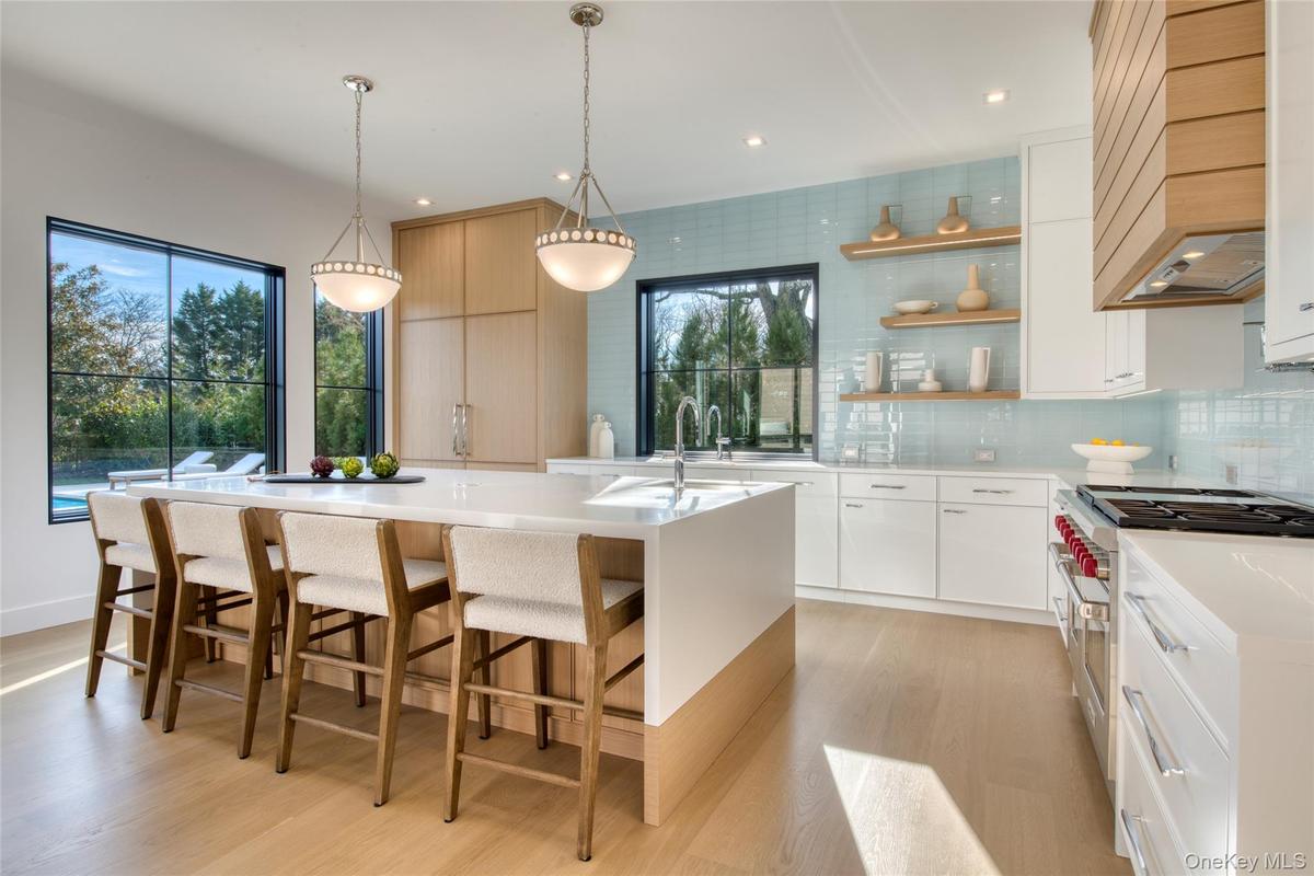 Kitchen featuring double oven range, open shelves, modern cabinets, custom exhaust hood, and tasteful backsplash