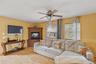 Living area featuring wood finished floors, a ceiling fan, and cooling unit