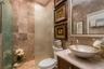 First floor full bath highlighting tile and quartz vanity top with bowl sink