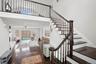 Stairs with a fireplace, a ceiling fan, recessed lighting, a high ceiling, and wood-type flooring