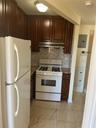 Kitchen with refrigerator, gas range gas stove, backsplash, dark brown cabinetry, and light marble finish flooring