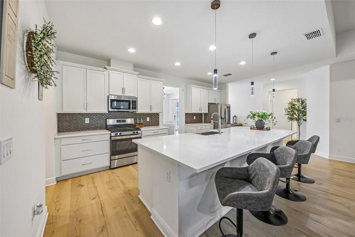 Not to be outdone, the interior delivers a bright, flowing layout anchored by a CHEF’S GOURMET KITCHEN that truly serves as the heart of the home.